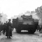 Photograph of a World War I Mark V (Male) Tank in Callander high street with crowds and woman in foreground, circa 1917 (Crown Copyright, National Records of Scotland, NSC1/392/1/8)
