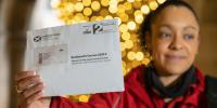 Image of postal worker holing a census letter
