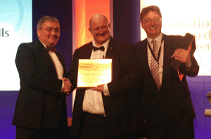 Photograph of presentation of the IRMS Records Management Team of the Year Award 2013 by Meic Pierce Owen, IRMS Treasurer, to Bruno Longmore, NRS Head of Government Records and Pete Wadley, Public Records Officer, of the PRSA implementation team.